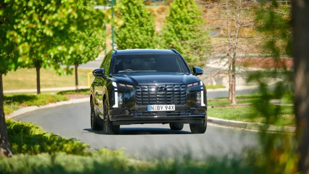 2024 Hyundai Palisade Calligraphy Black Ink driving on road