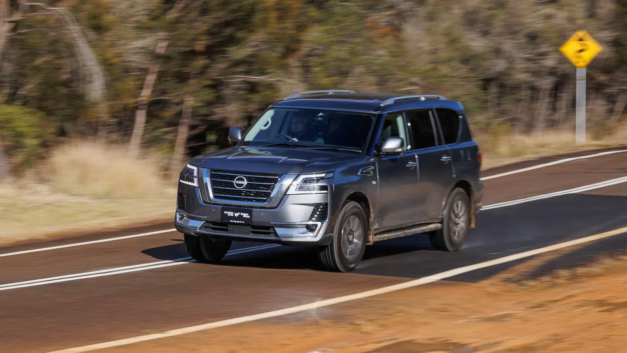 2024 Nissan Patrol Ti-L front angle driving past dirt